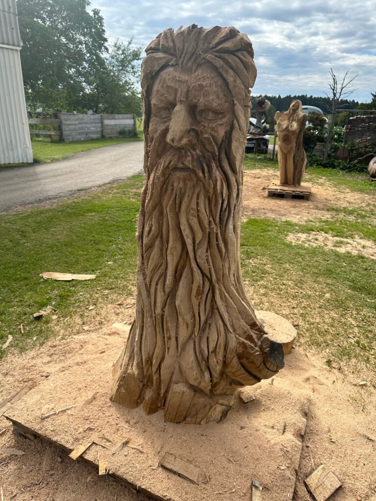 Holzskulptur eines weisen Mannes mit langem Bart.