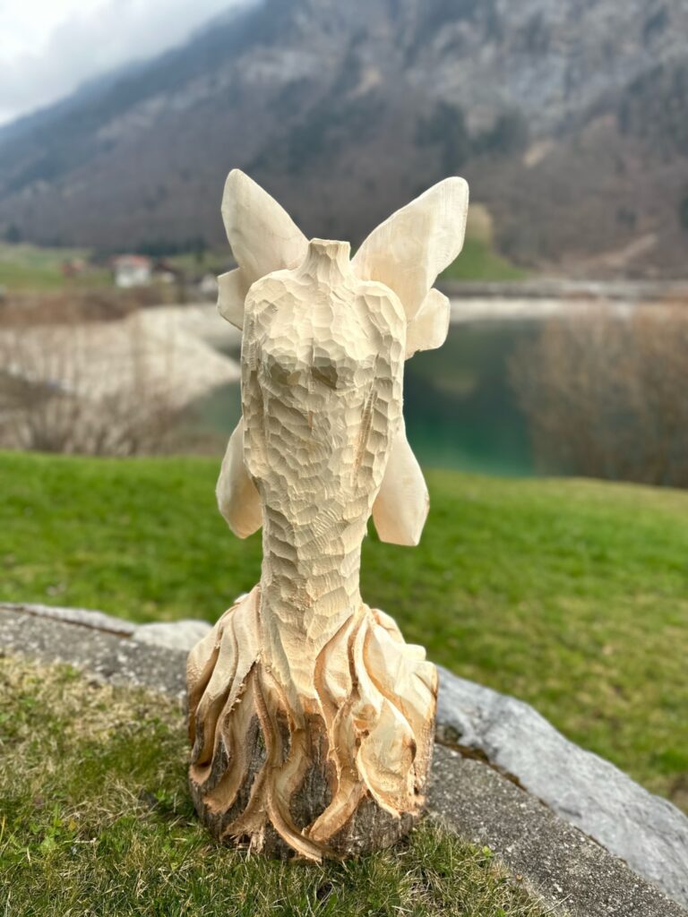 Holzskulptur des Körpers einer Fee mit Flügeln in der Natur.